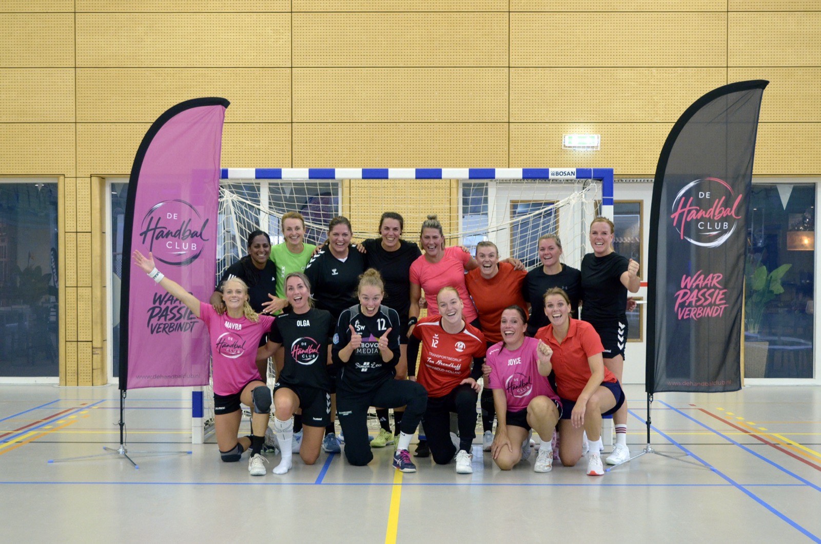 De groep speelsters van de Handbalclub tussen de twee beachflags voor het doel in de Bloesem, na de Match Day van 20 september